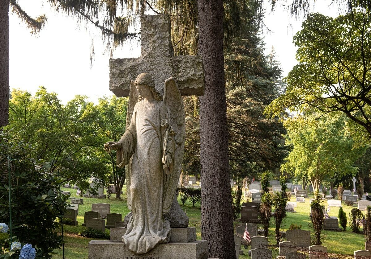 Sculpted headstone of a cross with an angel with open arms - Custom Memorial