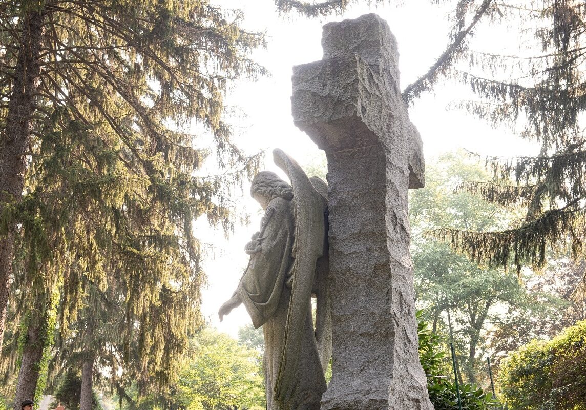 Upright monument of sculpted cross with an angel design